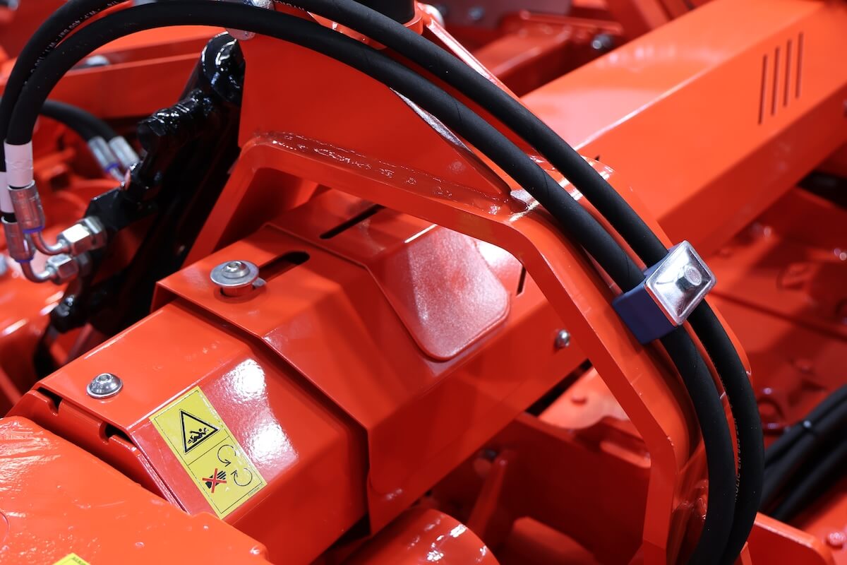 Dettaglio delle protezioni in acciaio degli alberi cardanici laterali con finestra d'ispezione sull'erpice Toro Super Rapido